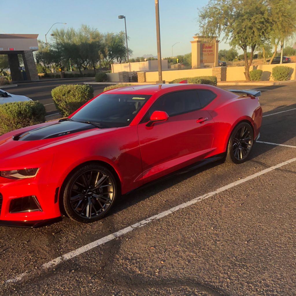 A red Chevy Camaro in a parking lot