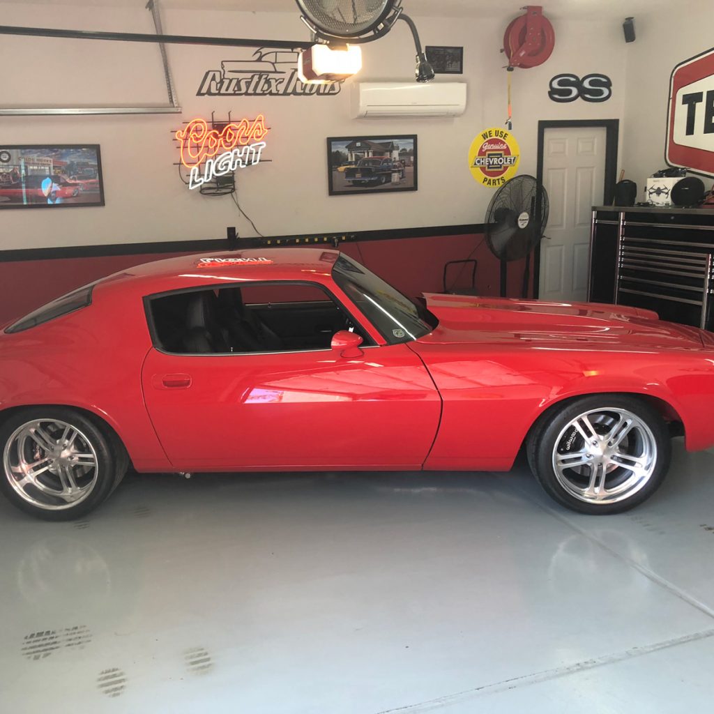 A red dodge challenger in a garage